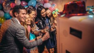 People in gathered in front of Photo Booths at Weddings with balloons behind them.