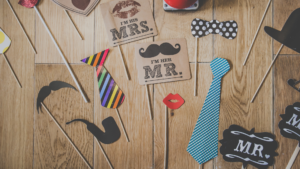 Wedding Photo booth accessories on a wooden floor for the discussion Are photo booths worth it?